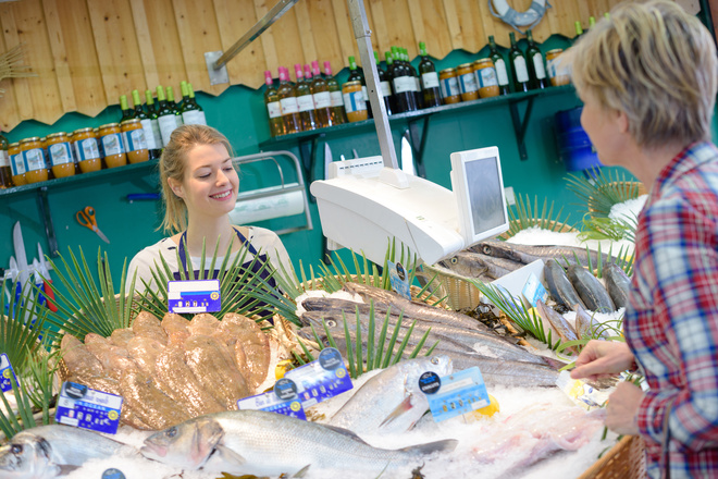 Cliente achète du poisson dans une poissonnerie artisanale