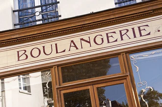 façade de boulangerie avec enseigne en lettres sur carrelage et vitrine en bois