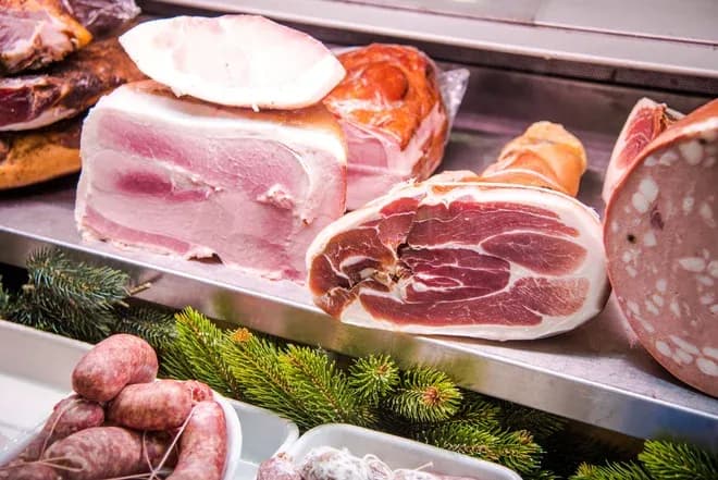 viande de charcuterie variée avec des tranches de jambon et des saucisses sur un présentoir