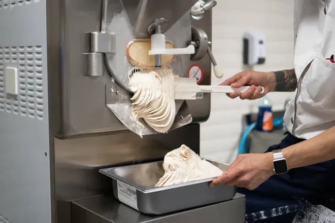 glace artisanale extrudée d'une machine professionnelle dans un bac
