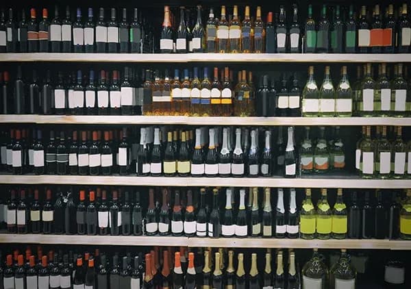 rayonnage de bouteilles de vin rouges blancs et effervescents alignées en magasin