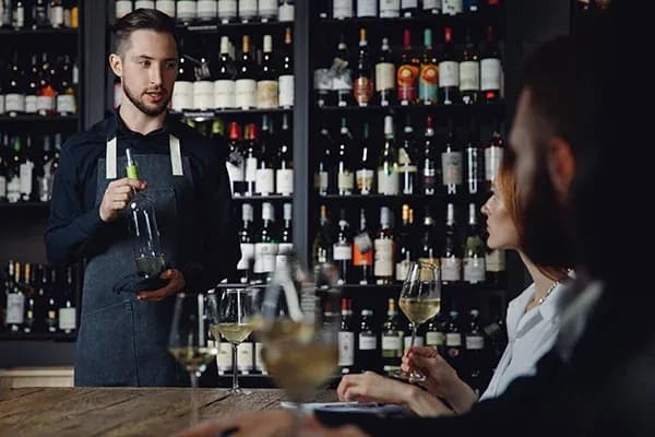 serveur présentant une bouteille lors d'une dégustation de vin en bar