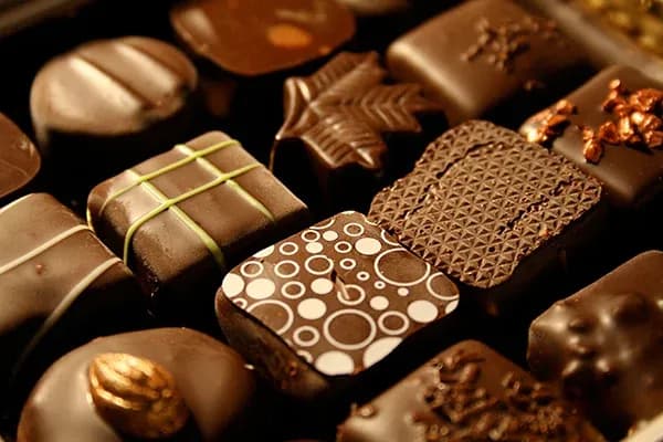 assortiment de chocolats variés avec différentes formes et motifs sur un fond sombre