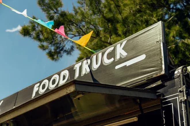 enseigne food truck sur camion avec guirlande de fanions colorés