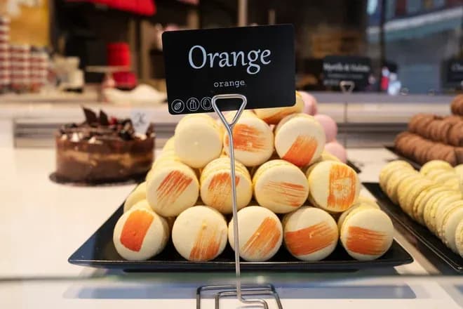 macarons goût orange empilés en pyramide avec stries orangées sur plateau