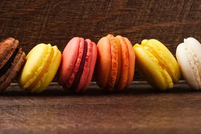 six macarons colorés alignés sur fond en bois