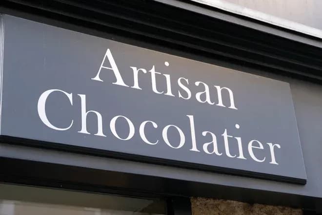 enseigne d'un chocolatier avec le mot artisan en lettres blanches sur fond noir
