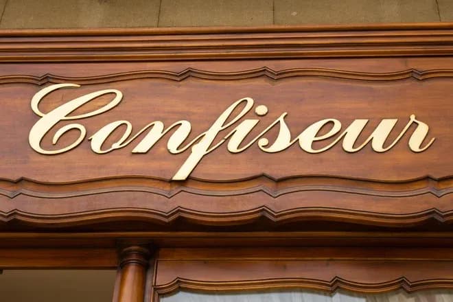 enseigne en bois gravée avec le mot confiseur en lettres dorées