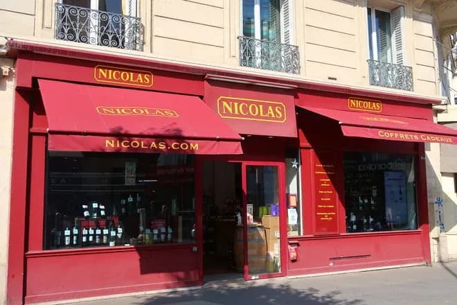 façade rouge de la boutique Nicolas avec bouteilles de vin en vitrine
