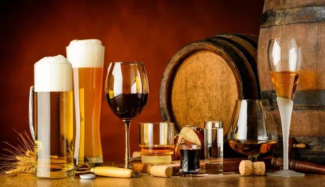verres de différentes boissons alcoolisées avec des fûts en bois en arrière-plan