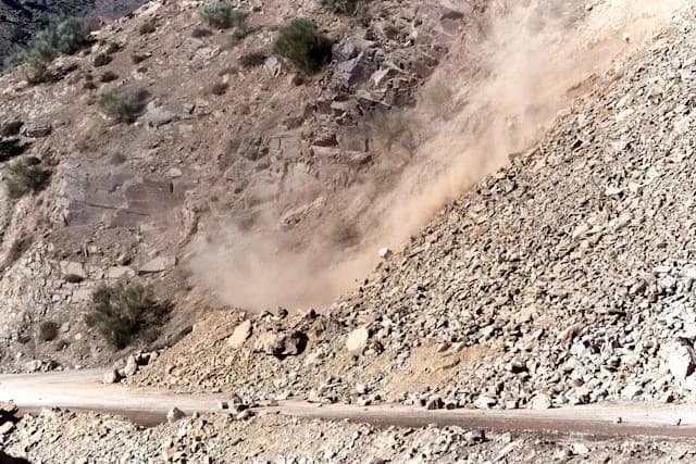 glissement de terrain sur un versant rocheux emportant des pierres vers la route