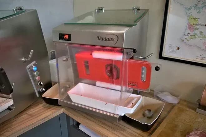 machine à steak haché Dadaux en inox avec poussoir rouge et bac de récupération blanc