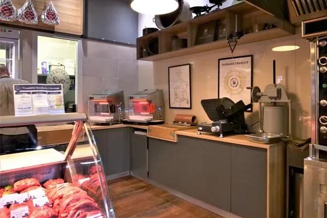 Comptoir de boucherie avec vitrine réfrigérée, trancheuse et machines d'emballage