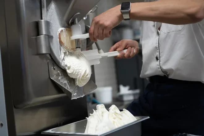 Préparation de crème glacée avec une machine à glace artisanale dans une cuisine professionnelle