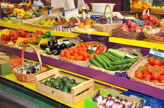 étal de primeur coloré avec tomates courgettes aubergines et fruits en paniers