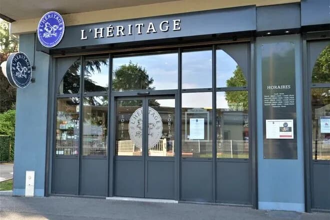 façade d'une boucherie avec enseigne l'héritage et panneaux d'information sur les horaires