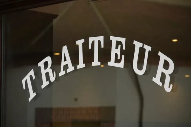 texte en lettres blanches sur une vitrine indiquant le mot traiteur