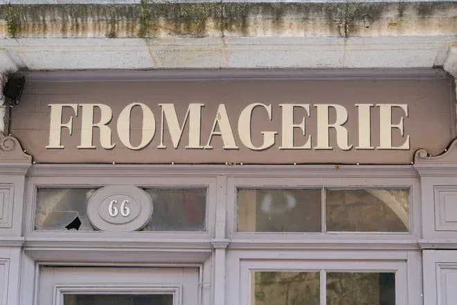 enseigne fromagerie au-dessus d'une porte d'entrée avec le numéro 66