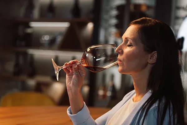 femme dégustant un verre de vin dans un intérieur élégant et chaleureux