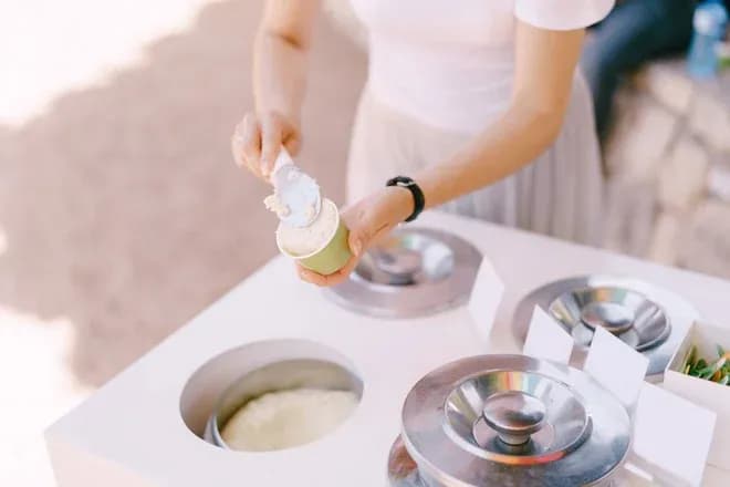personne servant une glace dans un gobelet depuis un glacier ambulant