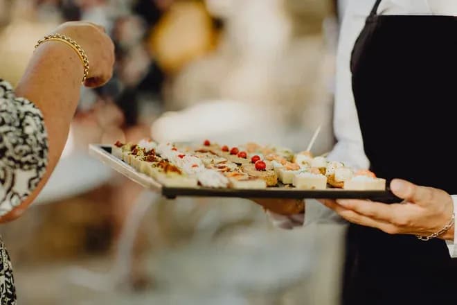 traiteur présentant un plateau de canapés variés