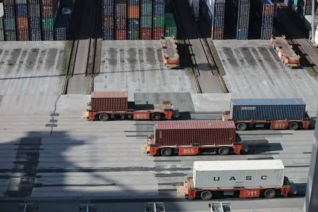 véhicules de manutention alignés transportant des conteneurs dans un terminal portuaire