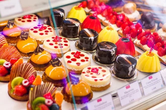 assortiment de pâtisseries colorées et entremets brillants dans une vitrine