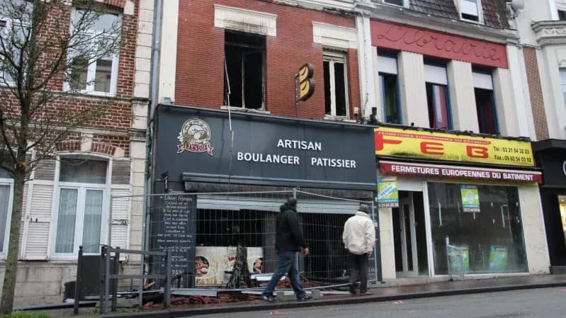 bâtiment de boulangerie avec des travaux en cours et des passants sur le trottoir