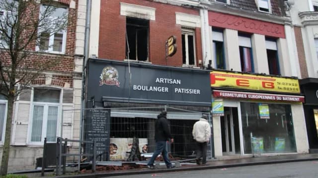 bâtiment de boulangerie avec des travaux en cours et des passants sur le trottoir