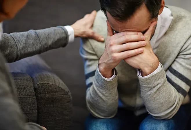 homme en détresse cachant son visage avec les mains pendant une conversation de soutien