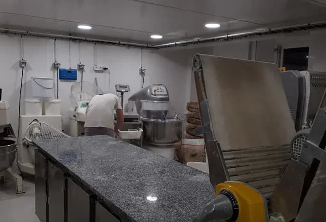 atelier de boulangerie avec équipements modernes et un homme en train de travailler à un plan de travail