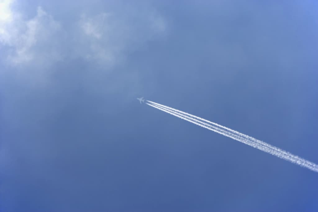 avion dans le ciel laissant une traînée de condensation derrière lui