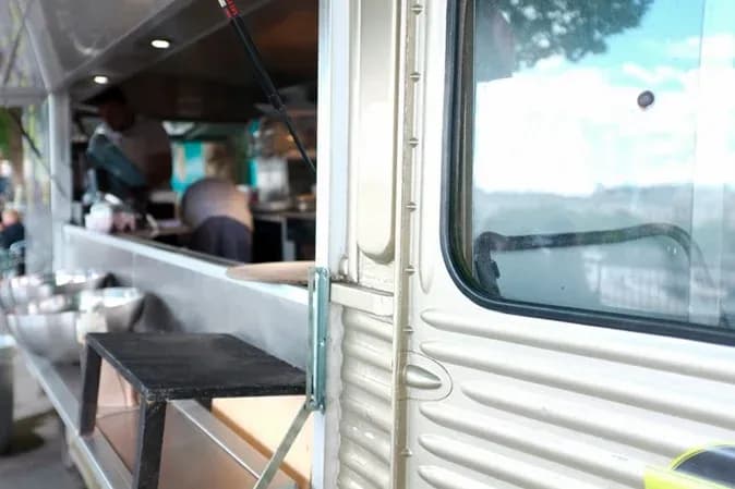 camion de restauration avec des préparations culinaires en arrière-plan et une vue sur l'extérieur