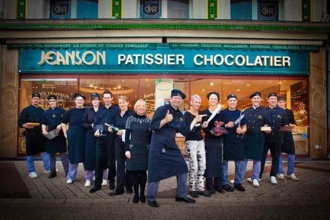 Équipe de pâtissiers devant la boutique Jeanson avec des gâteaux et des trophées