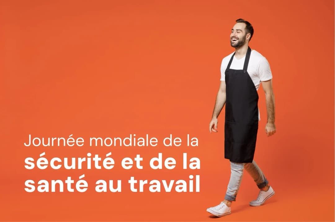 homme souriant en tenue de travail sur fond orange pour la journée de la sécurité au travail