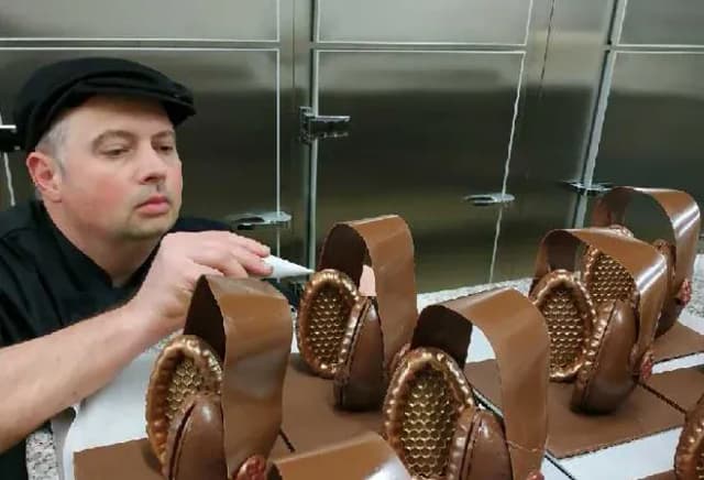 un chocolatier travaille sur des créations en chocolat avec des formes élaborées et détaillées
