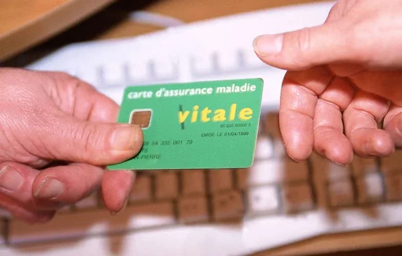 échange d'une carte vitale entre deux personnes sur un clavier d'ordinateur