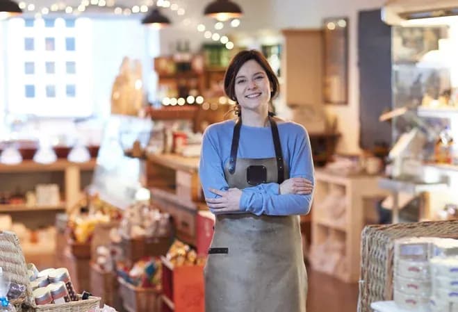 femme souriante dans une boutique d'alimentation avec des produits en arrière-plan