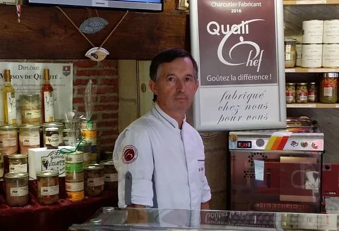 chef dans une boutique avec des produits alimentaires en arrière-plan