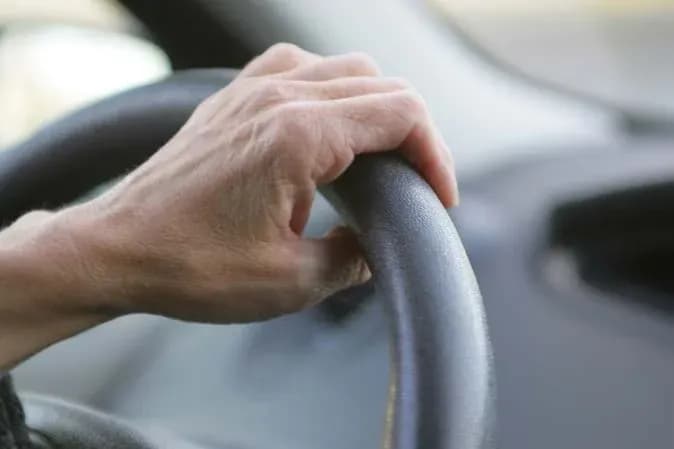main sur un volant de voiture en conduite