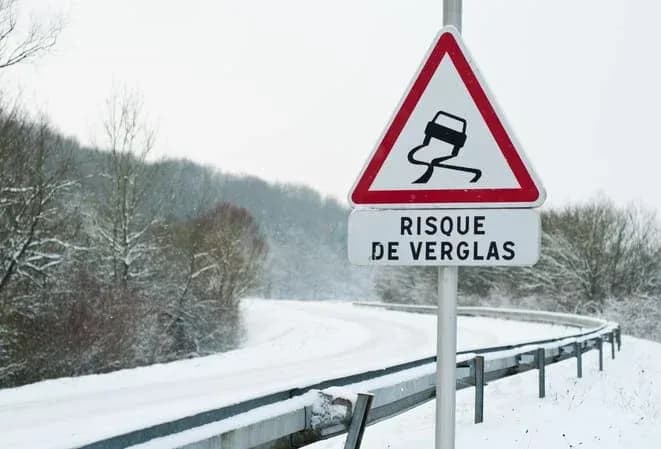 panneau de signalisation avertissant du risque de verglas sur une route enneigée