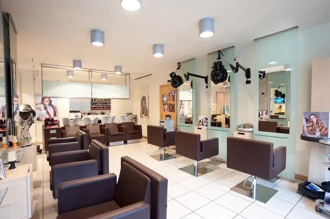salon de coiffure moderne avec fauteuils et postes de coiffure bien éclairés