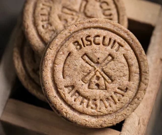 biscuits artisanaux ronds estampés d'un moulin dans une caissette en bois