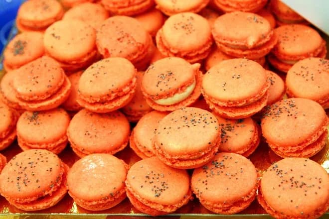 macarons orange garnis de crème saupoudrés de graines de pavot