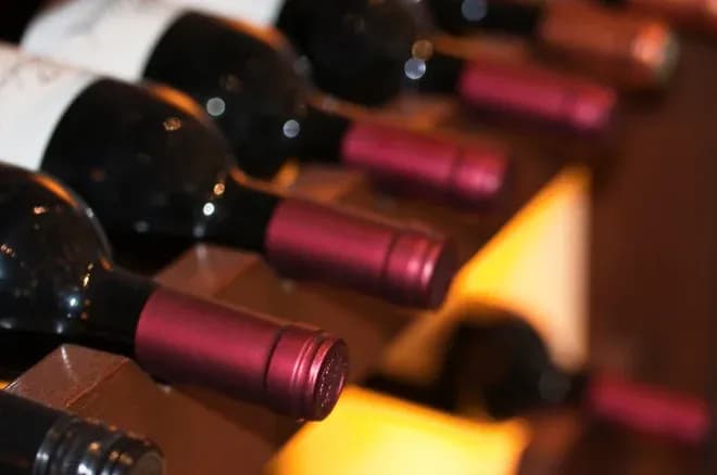 bouteilles de vin couchées dans un casier en bois éclairé