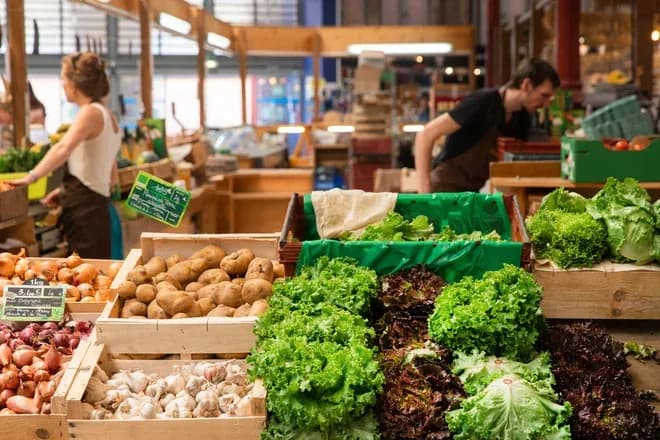 étals de fruits et légumes frais avec des clients au marché local