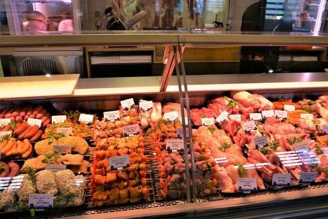 comptoir de boucherie avec brochettes, saucisses et pièces de viande étiquetées