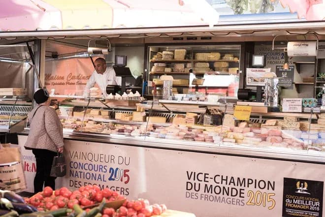 étal de fromages primés au marché vendeur servant une cliente