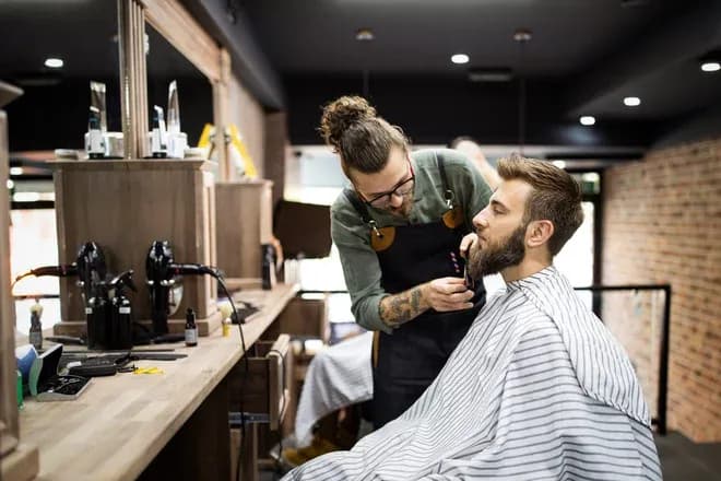barbier taille la barbe d'un client dans un salon moderne