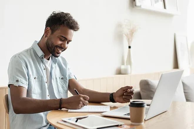 étudiant suit un cours de boulangerie en ligne et prend des notes